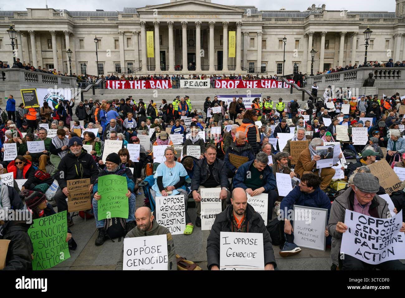 Pro-Palestinian protesters holding a placards at a "Lift The Ban" demonstration, referencing Palestine Action, in Trafalgar Square.