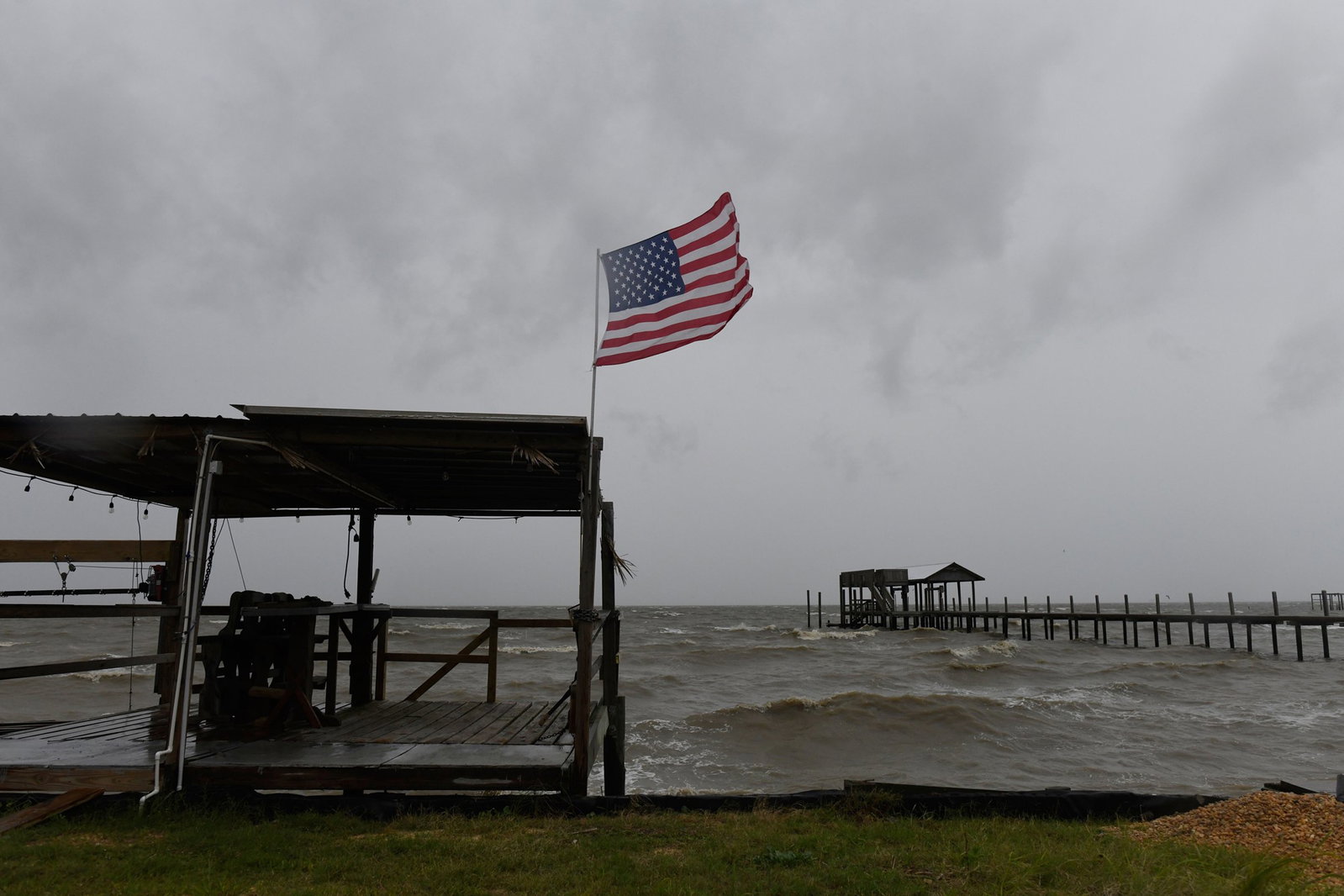 An American flag flaps in the wind generated by the effects of Isaias on an empty beach on Friday, Oct. 9, 2026. (Octavio Jones/AP)