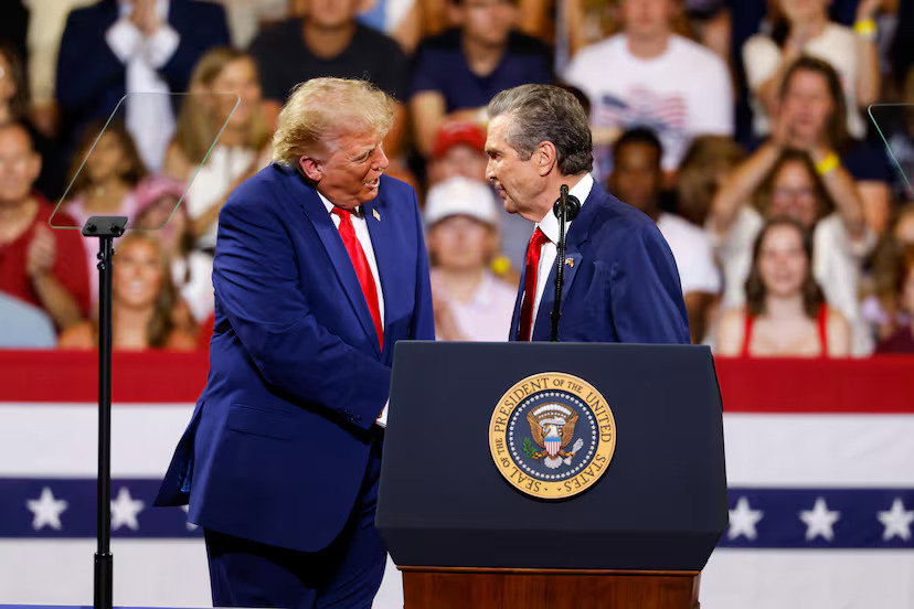 President Donald Trump (left) shakes hands with Republican nominee for governor Rick Jackson during Trump’s rally at Wheeler High School in Marietta in July.