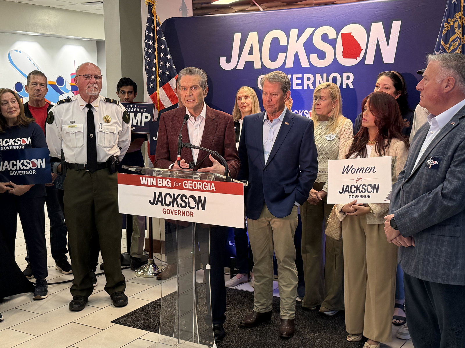Republican nominee for governor Rick Jackson, at lectern, speaks to supporters as Gov. Brian Kemp (right) listens during a campaign event in Atlanta on Monday.