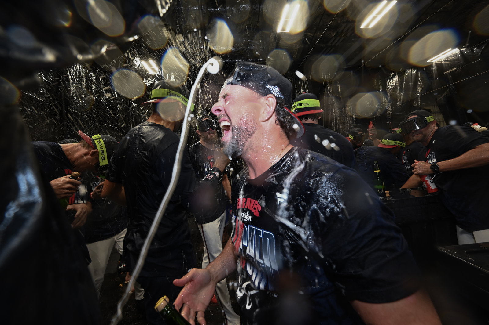 The Atlanta Braves celebrate in the clubhouse after defeating the Philadelphia Phillies in the ninth inning of Game 3 to win an MLB National League Wild Card playoff series.